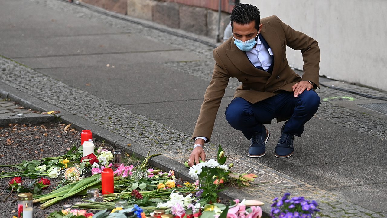 Ismet Tekin, Betreiber des Kiez Döners, legt vor seinem Imbiss Blumen an einer Gedenkplatte für die Opfer des Anschlages von Halle nieder