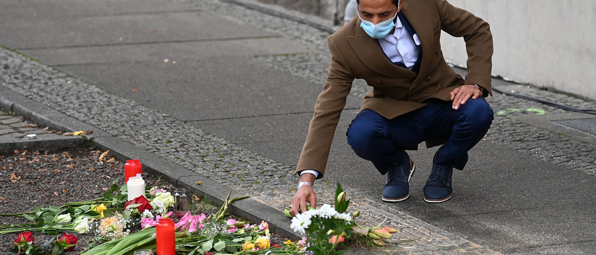 Ismet Tekin, Betreiber des Kiez Döners, legt vor seinem Imbiss Blumen an einer Gedenkplatte für die Opfer des Anschlages von Halle nieder