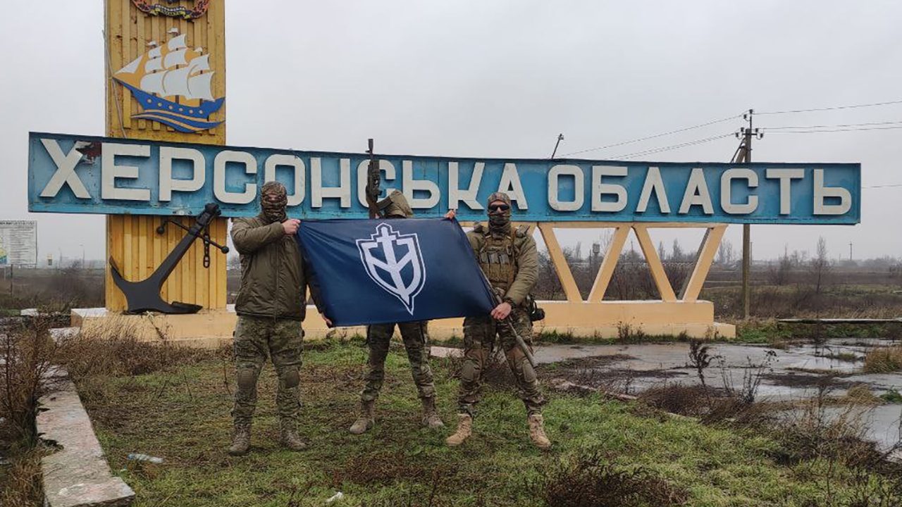 Kämpfer des rechtsextremen „Russischen Freiwilligenkorps“ posieren mit Flagge in Cherson