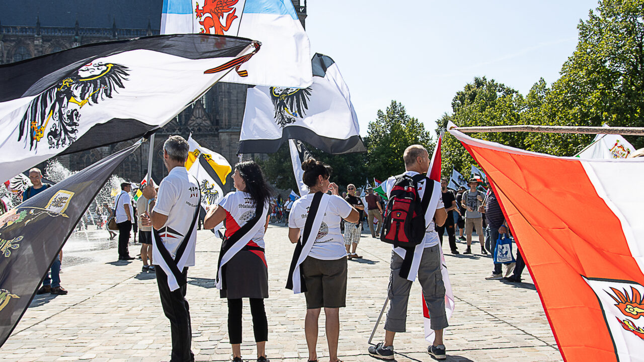 Mehrere Teilnehmer tragen Fahnen auf Reichsbürgerveranstaltung